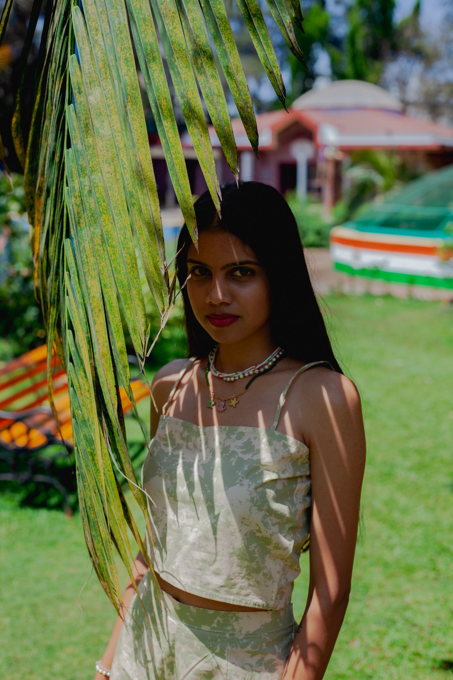 Close-up of printed poplin crop top featuring asymmetrical hem, and spaghetti straps.