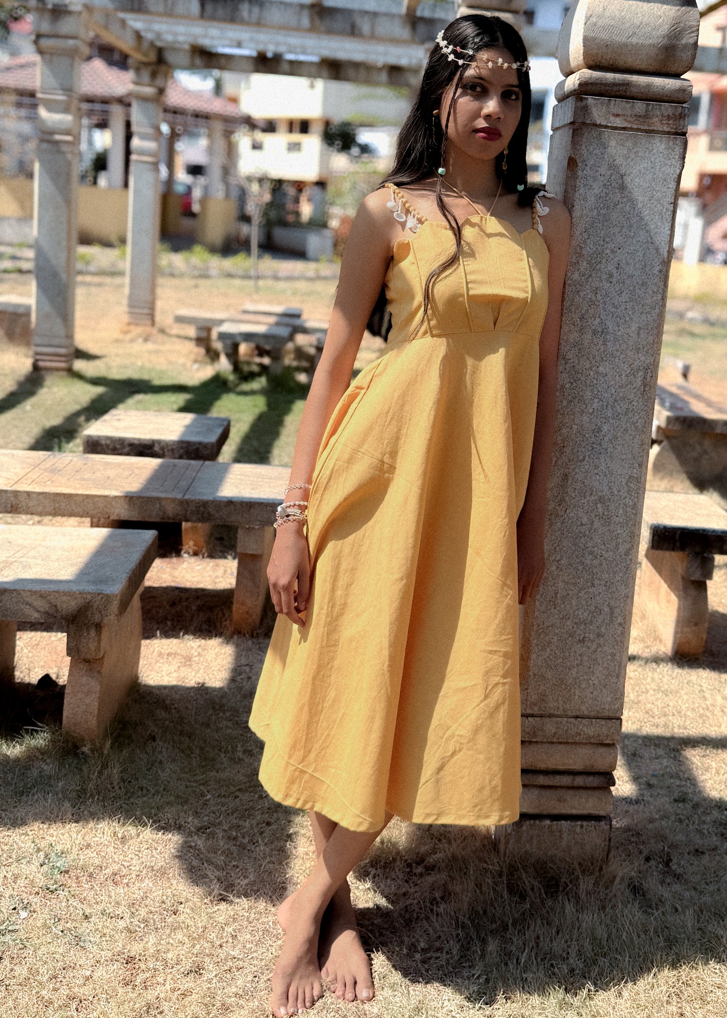 Yellow cotton-linen Sandshells Midi Dress with scalloped neckline, fabric pearl straps with shells and seed beads hanging, and shell inspired yoke with circular-skirt.