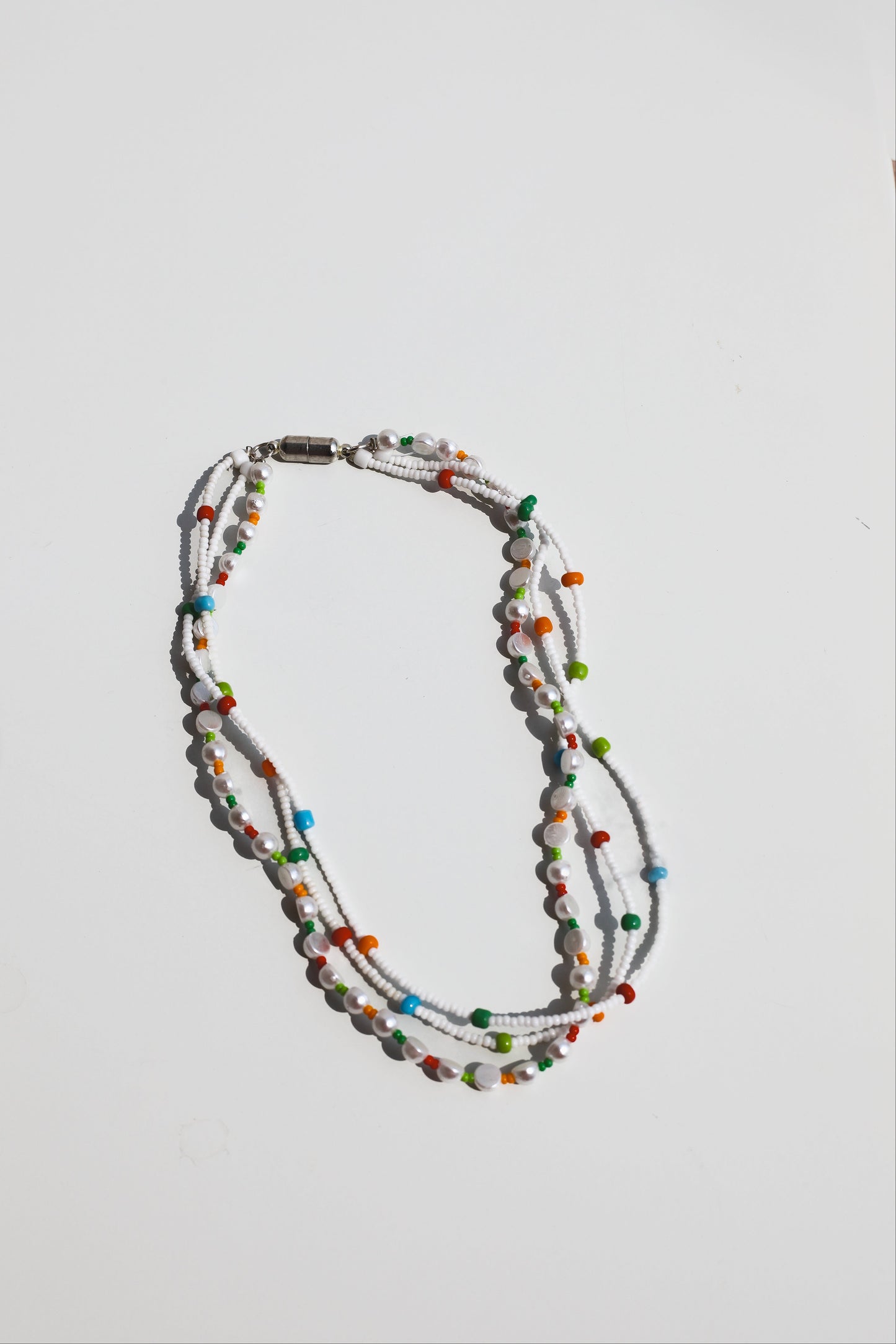 Multicolored beaded necklace on a light gray background