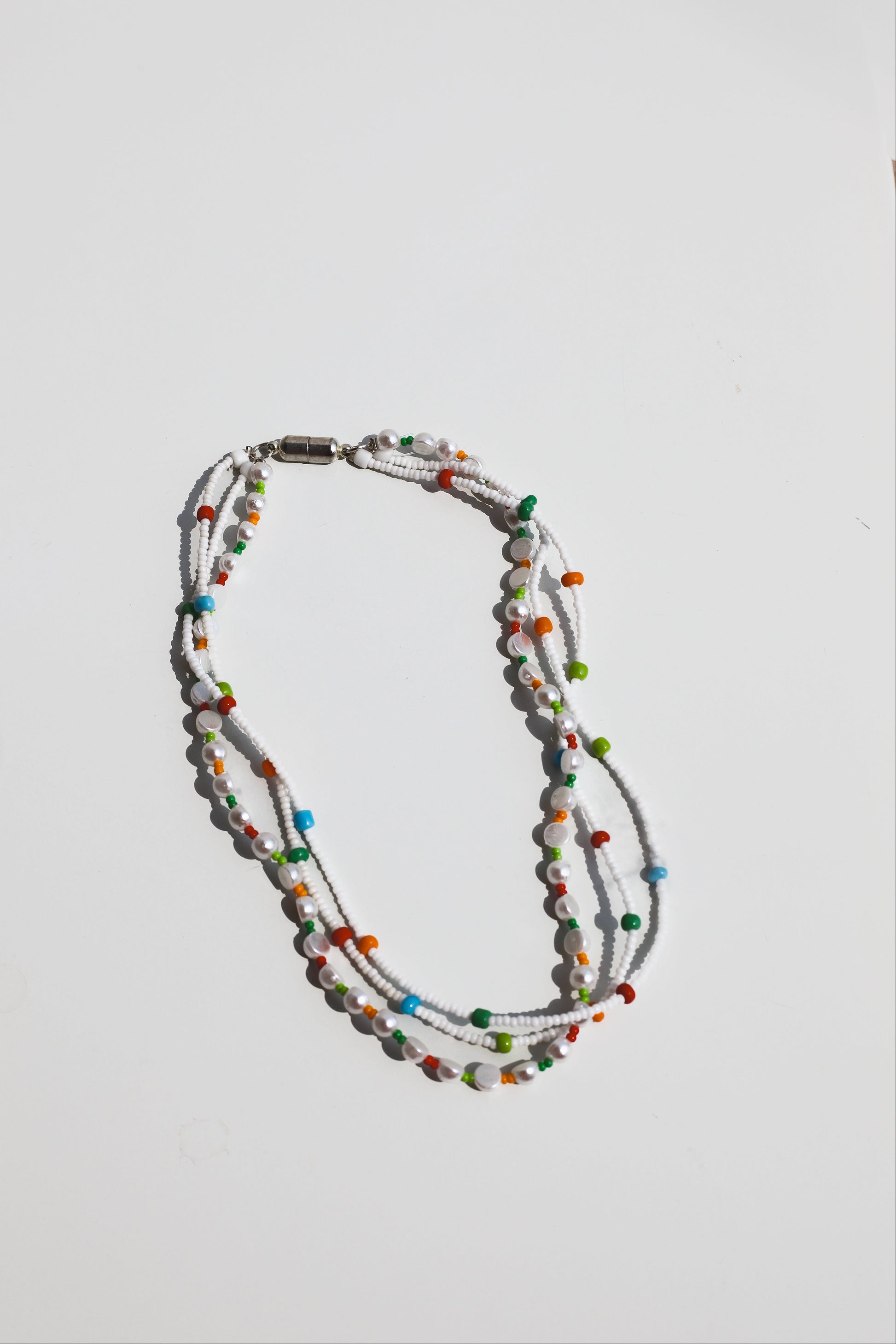 Multicolored beaded necklace on a light gray background
