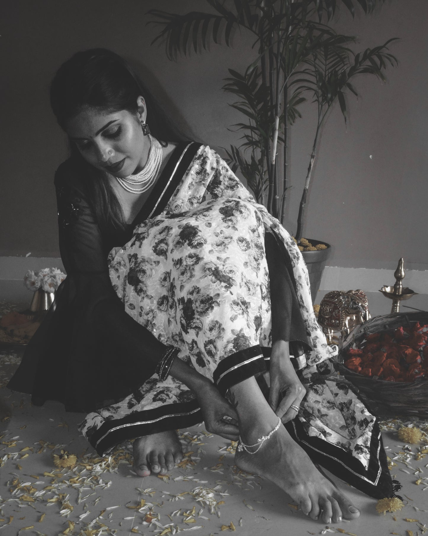 Model wearing black and white rose printed Guldasta Saree featuring intricate self-tone white embroidery, with a black velvet and silver gotta patti border.