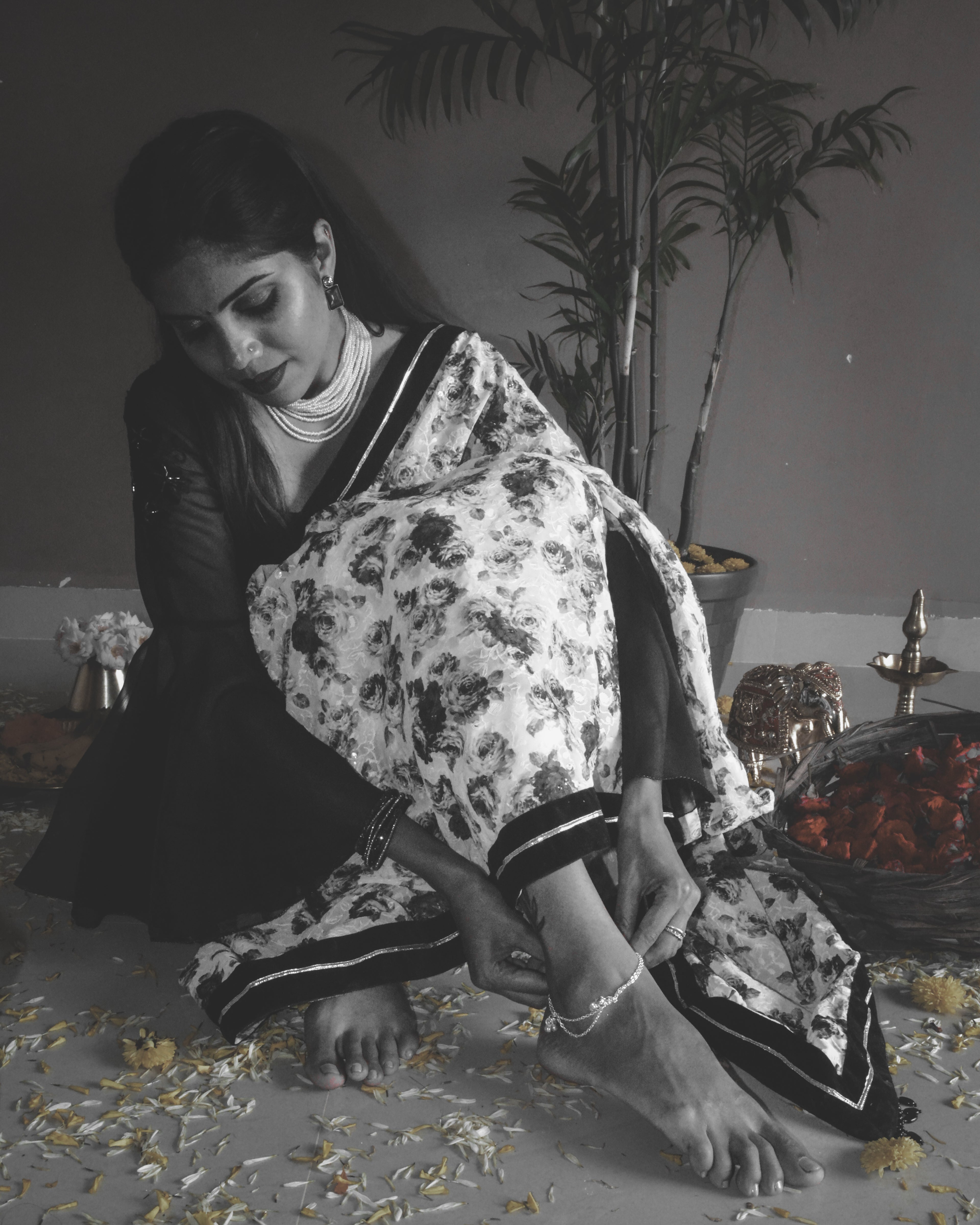 Model wearing black and white rose printed Guldasta Saree featuring intricate self-tone white embroidery, with a black velvet and silver gotta patti border.