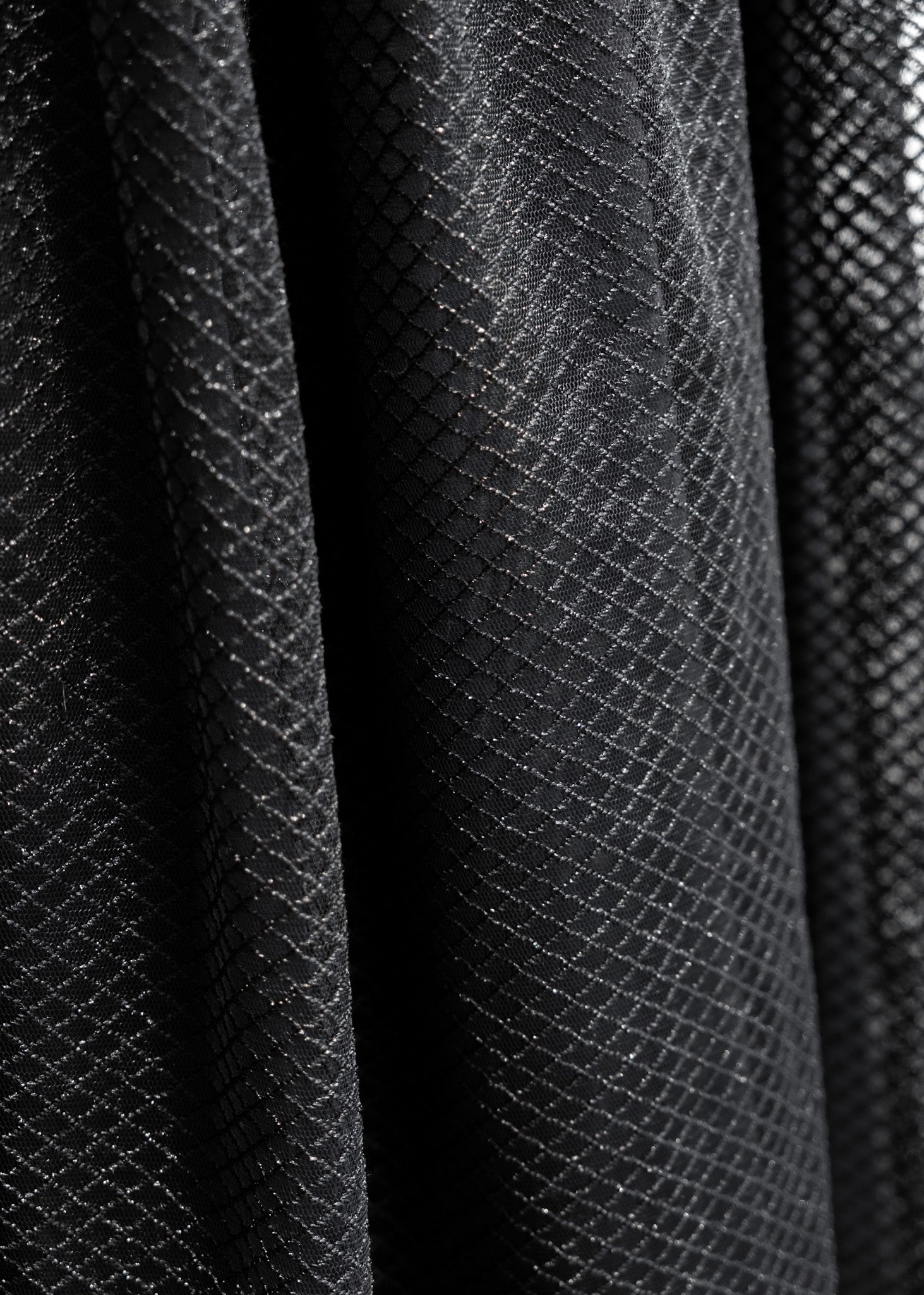 Close-up of black diamond-patterned tulle  dress