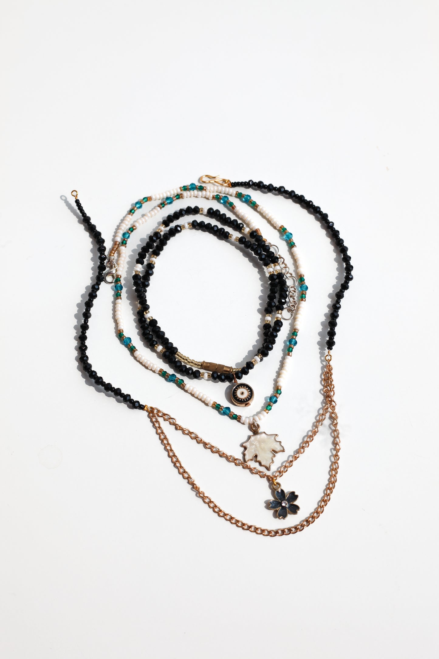 Set of layered necklaces with beads and chains on a white background