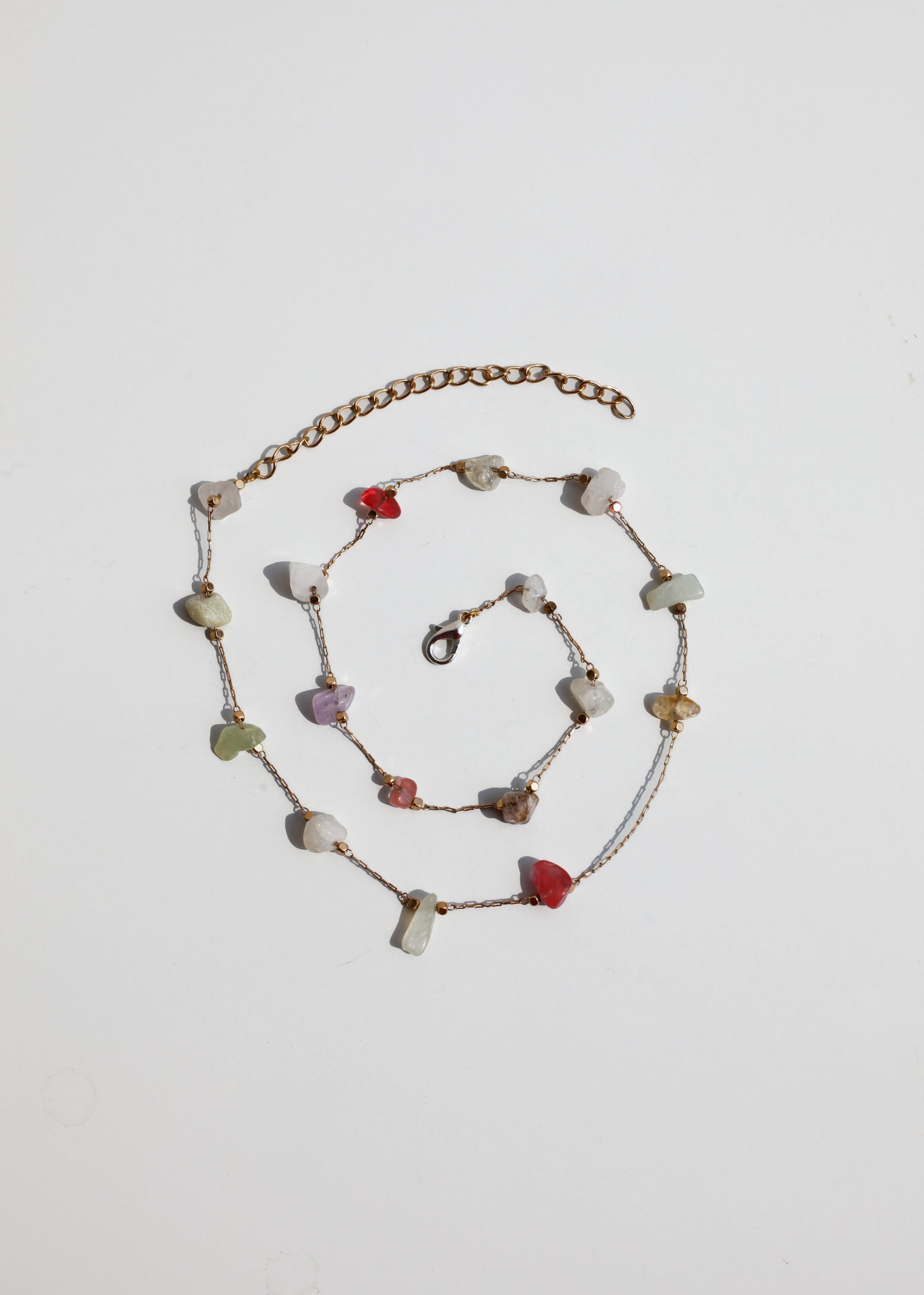 Necklace with multicolored stones on a light gray background