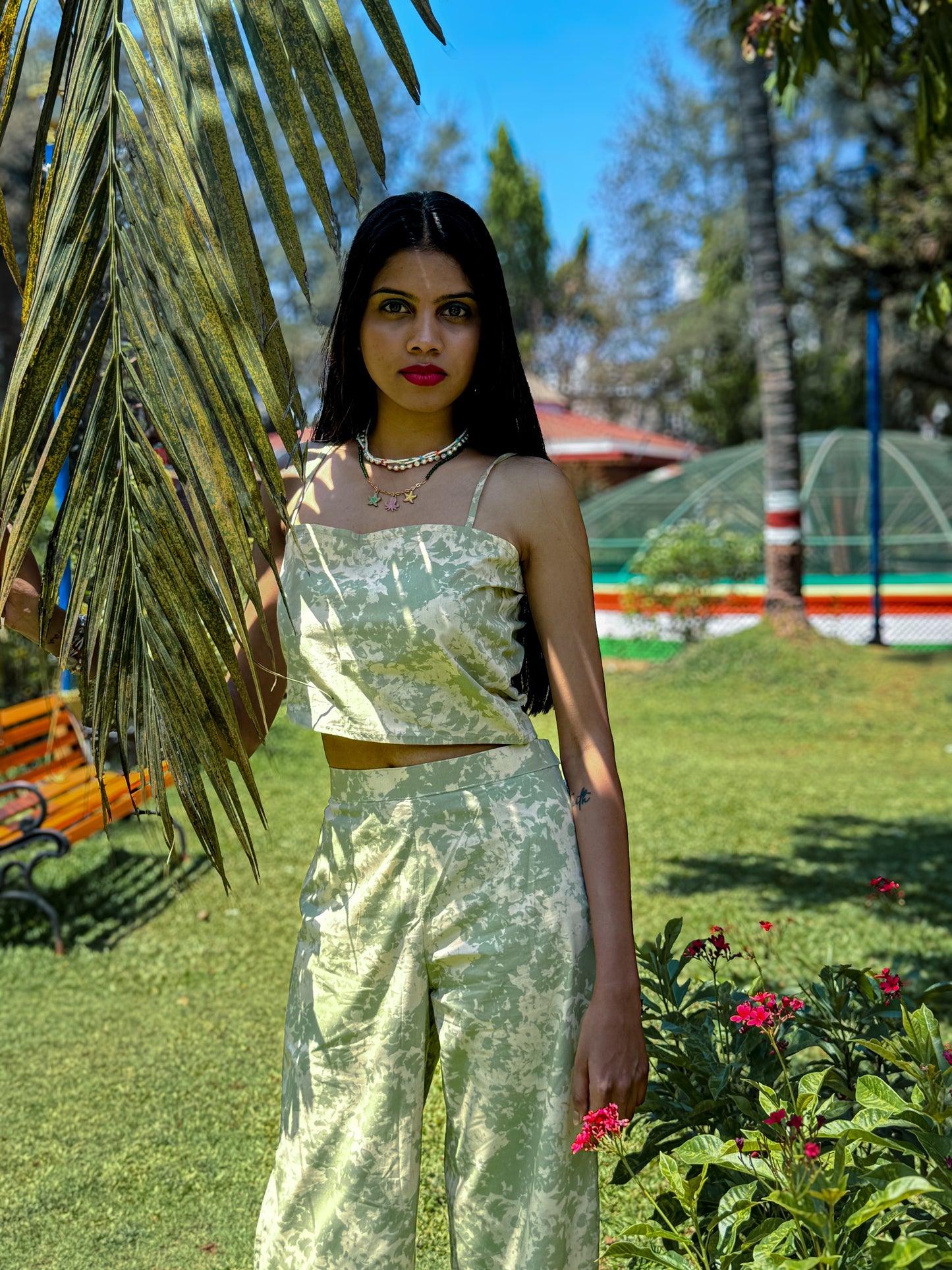 Sage Green and beige printed poplin Pista Swirl asymmetrical crop top with spaghetti straps paired with matching trousers.