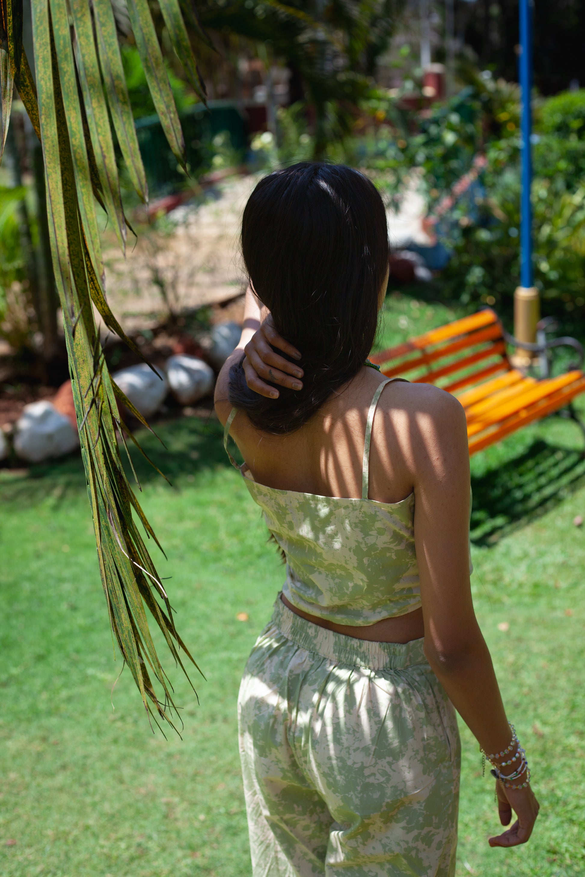 Back view of the sage green and beige printed poplin asymmetrical crop top.