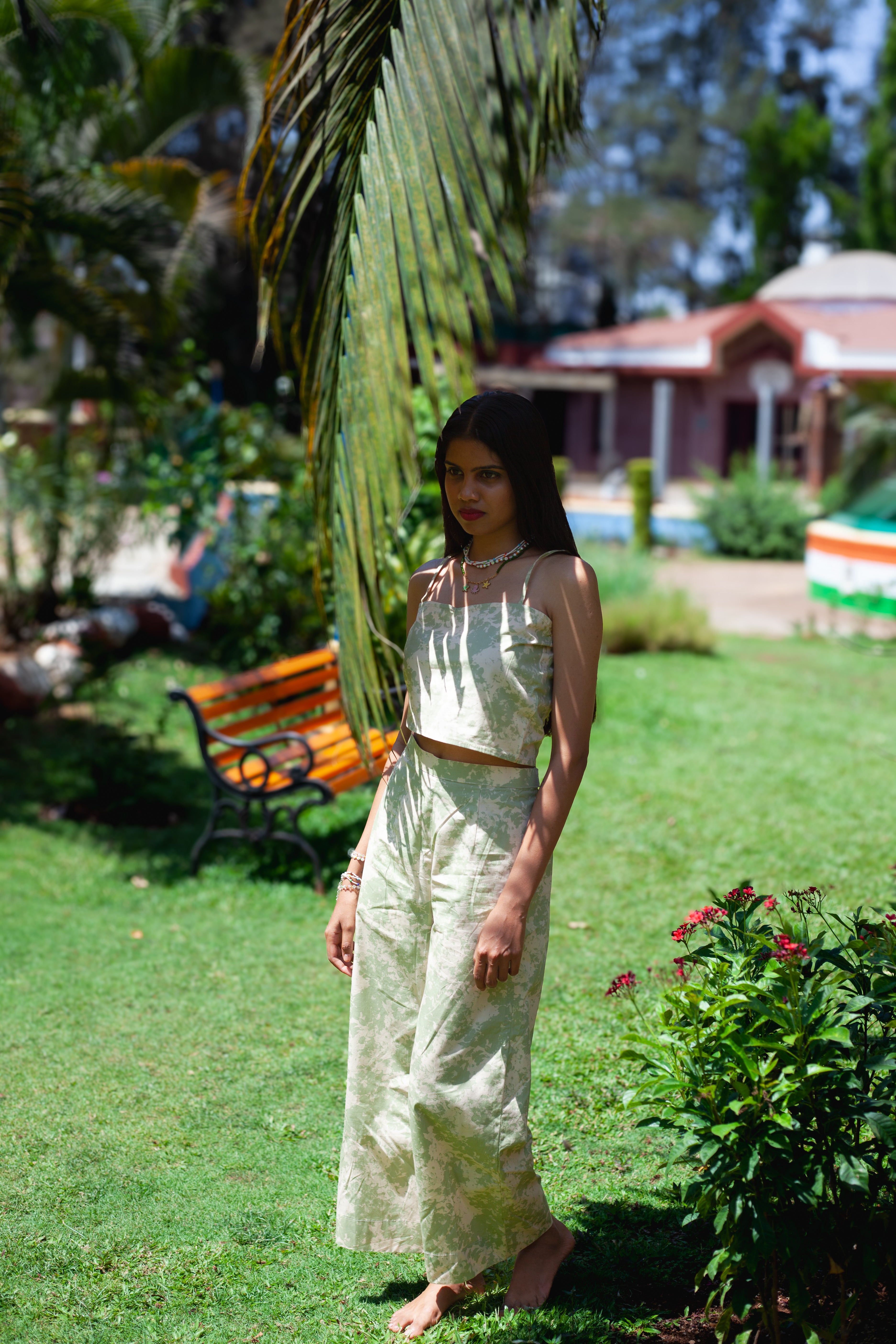 Side view of sage green printed poplin trousers paired with matching asymmetrical crop top from Tales Of Summer collection.