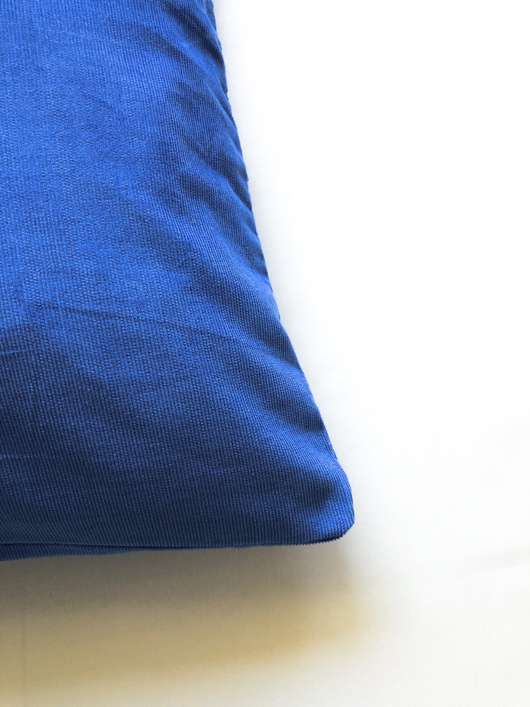 Close-up detail of cobalt blue cotton cushion cover with white textured wave embroidery, inspired by ocean waves. This modern, handcrafted cushion is perfect for coastal, boho, or minimalist home décor. Ideal for sofas, beds, and lounge spaces, adding a stylish and elegant touch.