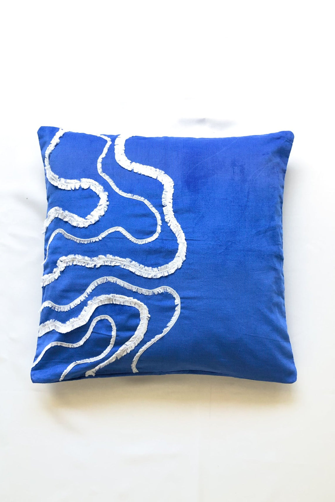 Cobalt blue cotton cushion cover with white textured wave embroidery, inspired by ocean waves. This modern, handcrafted cushion is perfect for coastal, boho, or minimalist home décor. Ideal for sofas, beds, and lounge spaces, adding a stylish and elegant touch.