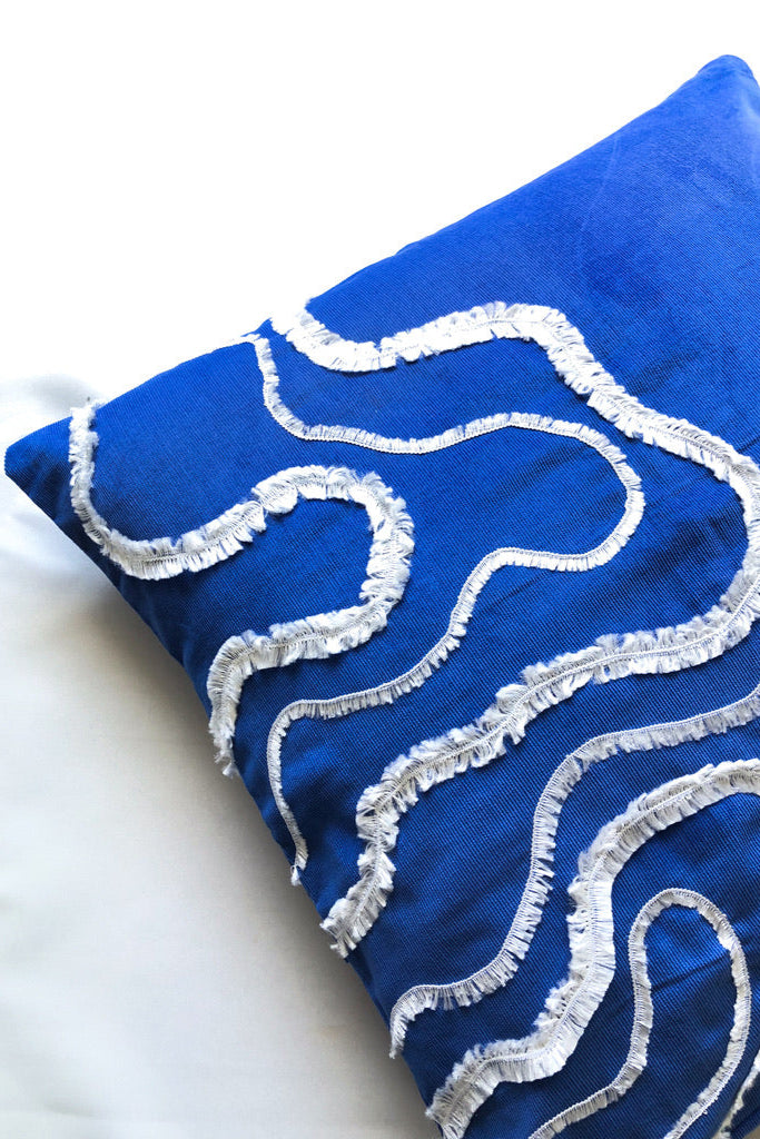 Close-up detail of cobalt blue cotton cushion cover with white textured wave embroidery, inspired by ocean waves. This modern, handcrafted cushion is perfect for coastal, boho, or minimalist home décor. Ideal for sofas, beds, and lounge spaces, adding a stylish and elegant touch.