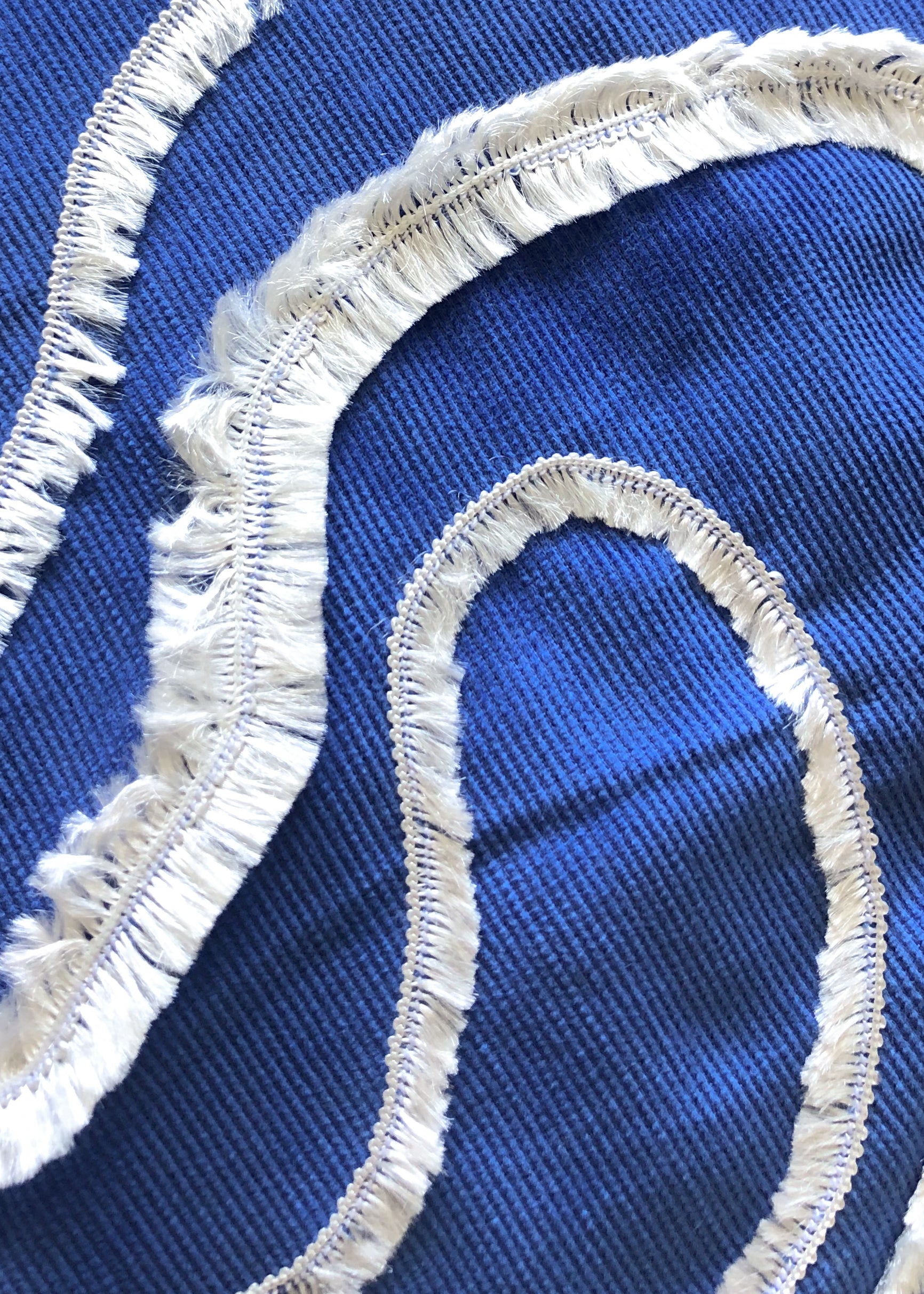 Close-up detail of cobalt blue cotton cushion cover with white textured wave embroidery, inspired by ocean waves. This modern, handcrafted cushion is perfect for coastal, boho, or minimalist home décor. Ideal for sofas, beds, and lounge spaces, adding a stylish and elegant touch.