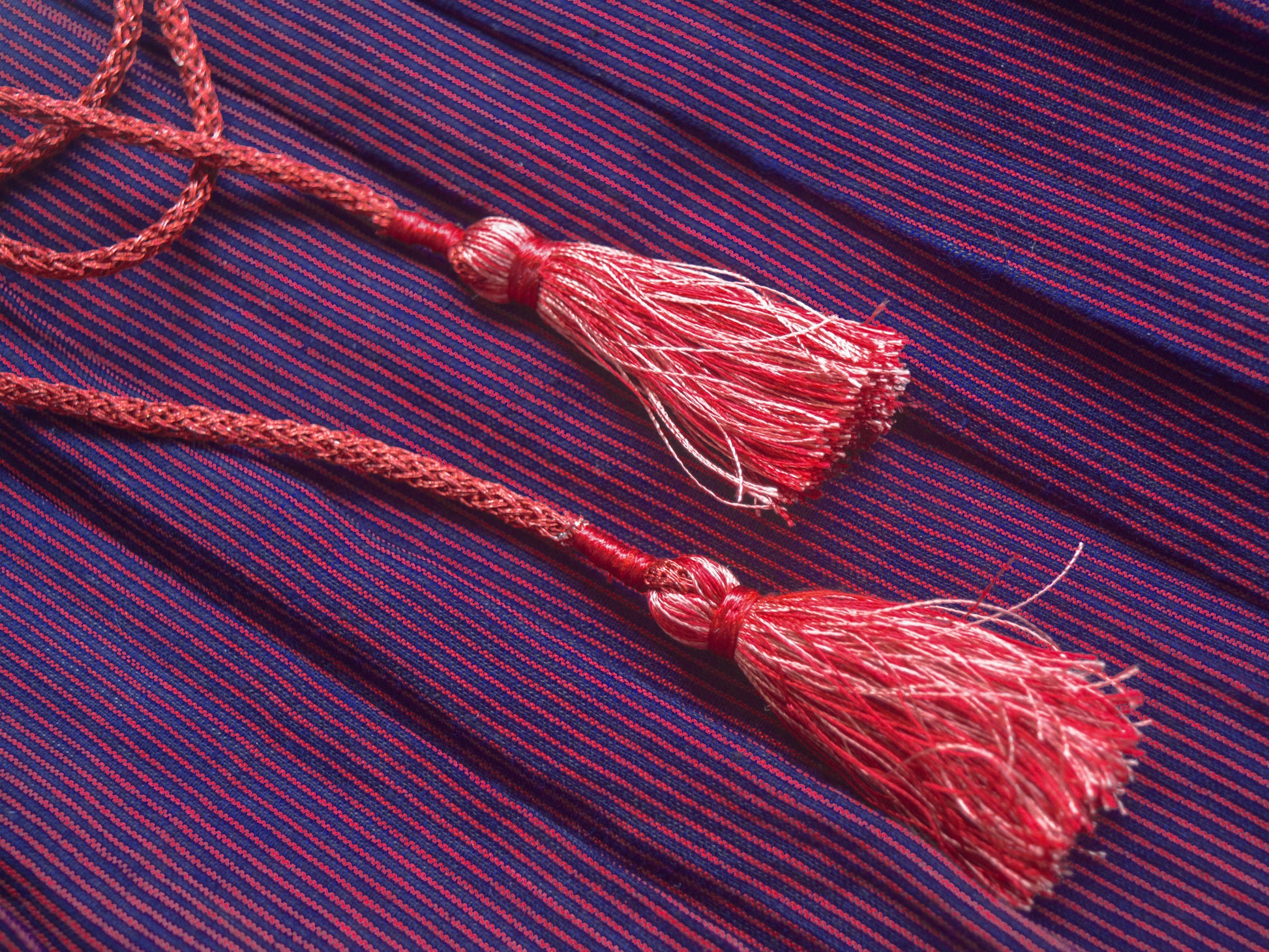 Close-up of the purple stripe cotton fabric of the Jamini Tunic, showing its texture, and tassels.