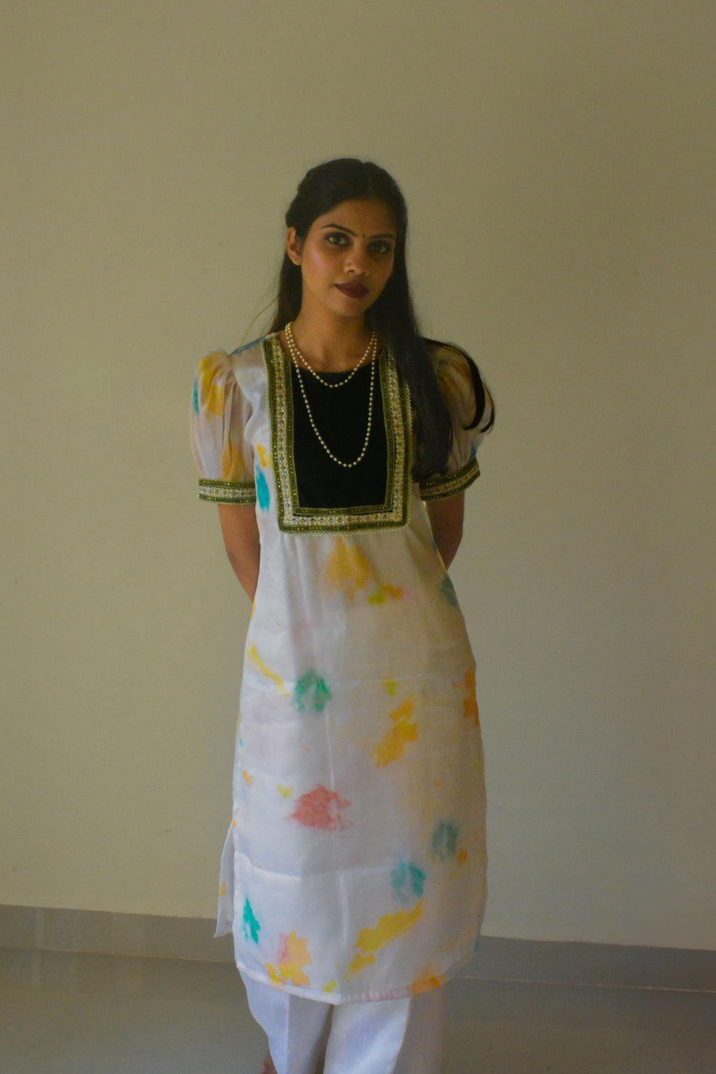 Woman wearing a white organza traditional kurta with a plain background