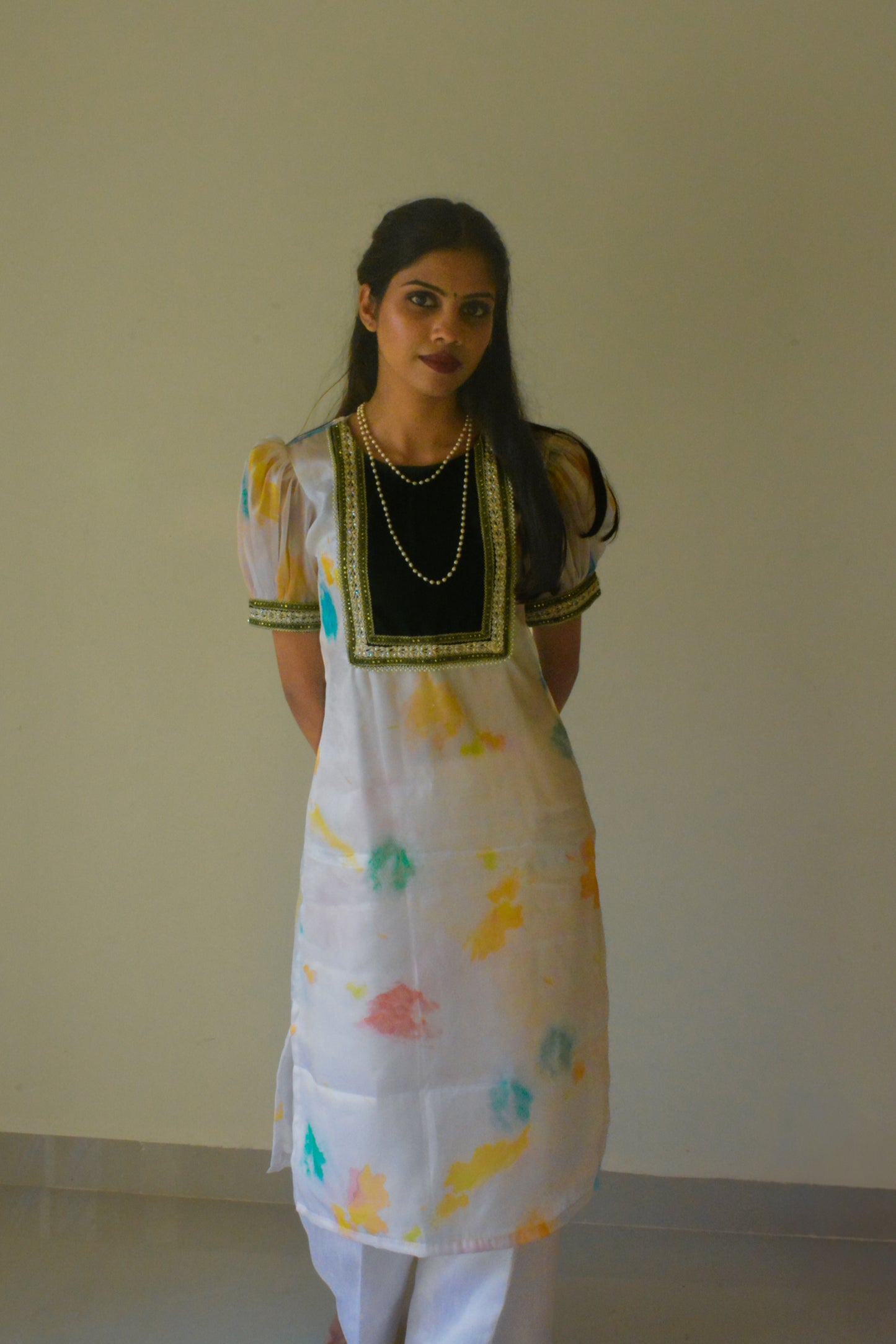 Woman wearing a white organza traditional kurta with a plain background