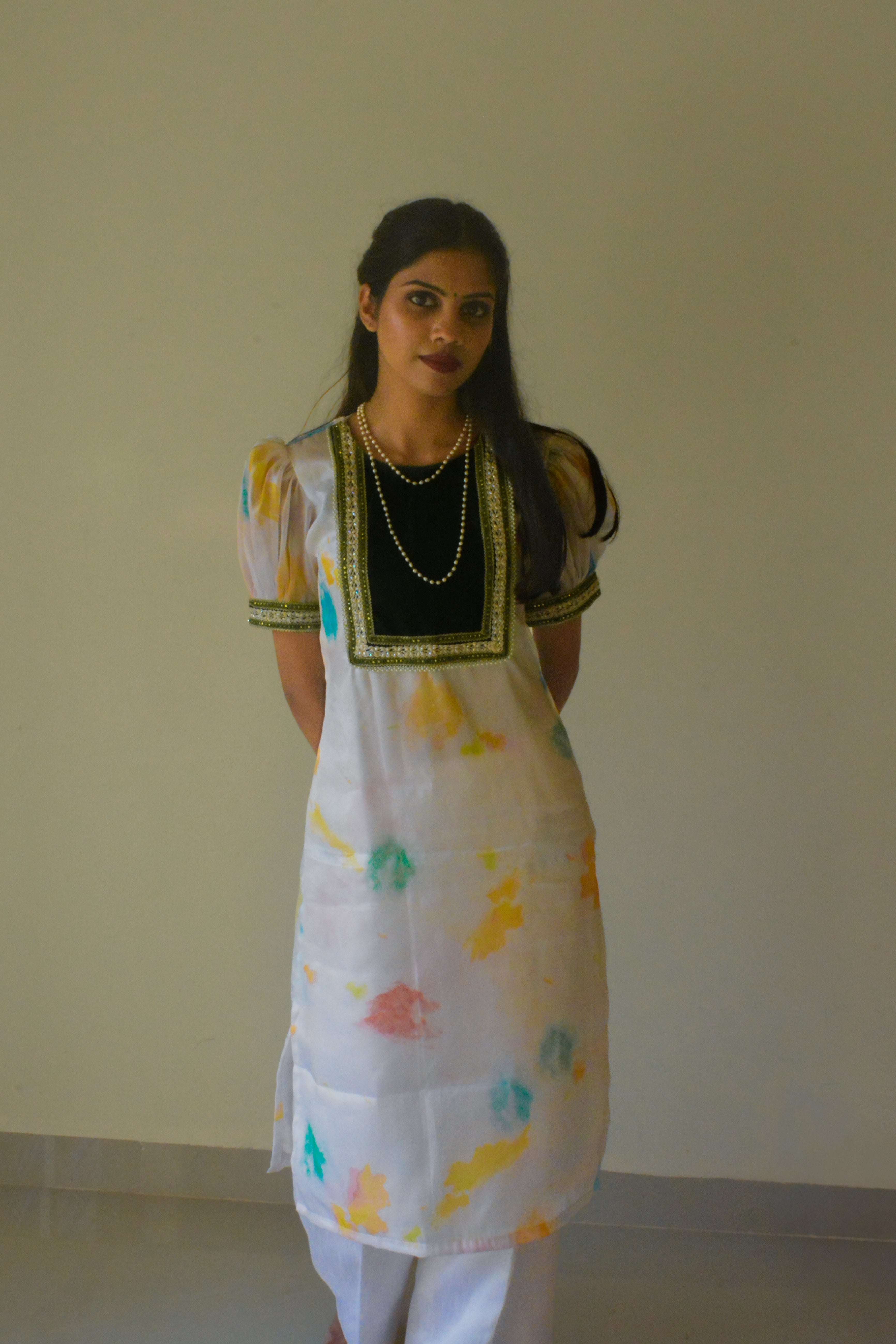 Woman wearing a white organza traditional kurta with a plain background