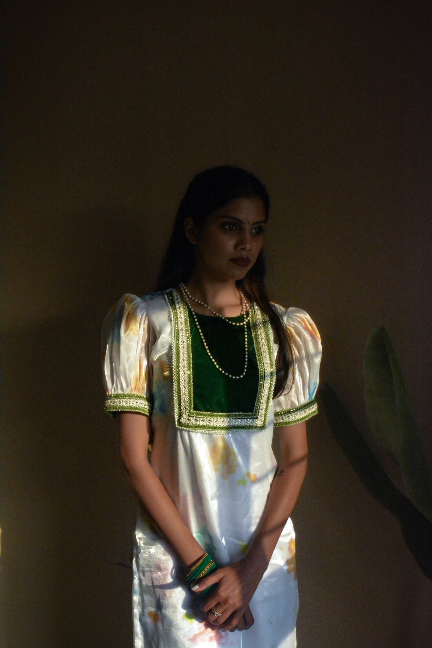 Woman wearing a white organza traditional kurta with a dark background