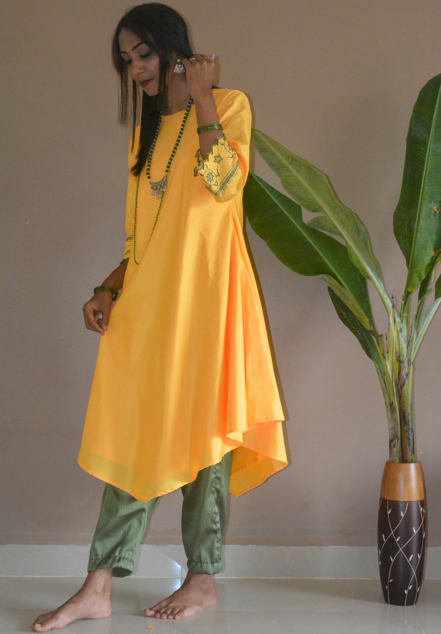 Side view of the yellow-green muslin silk shevanti kurta det, showing the asymmetrical drape and length.