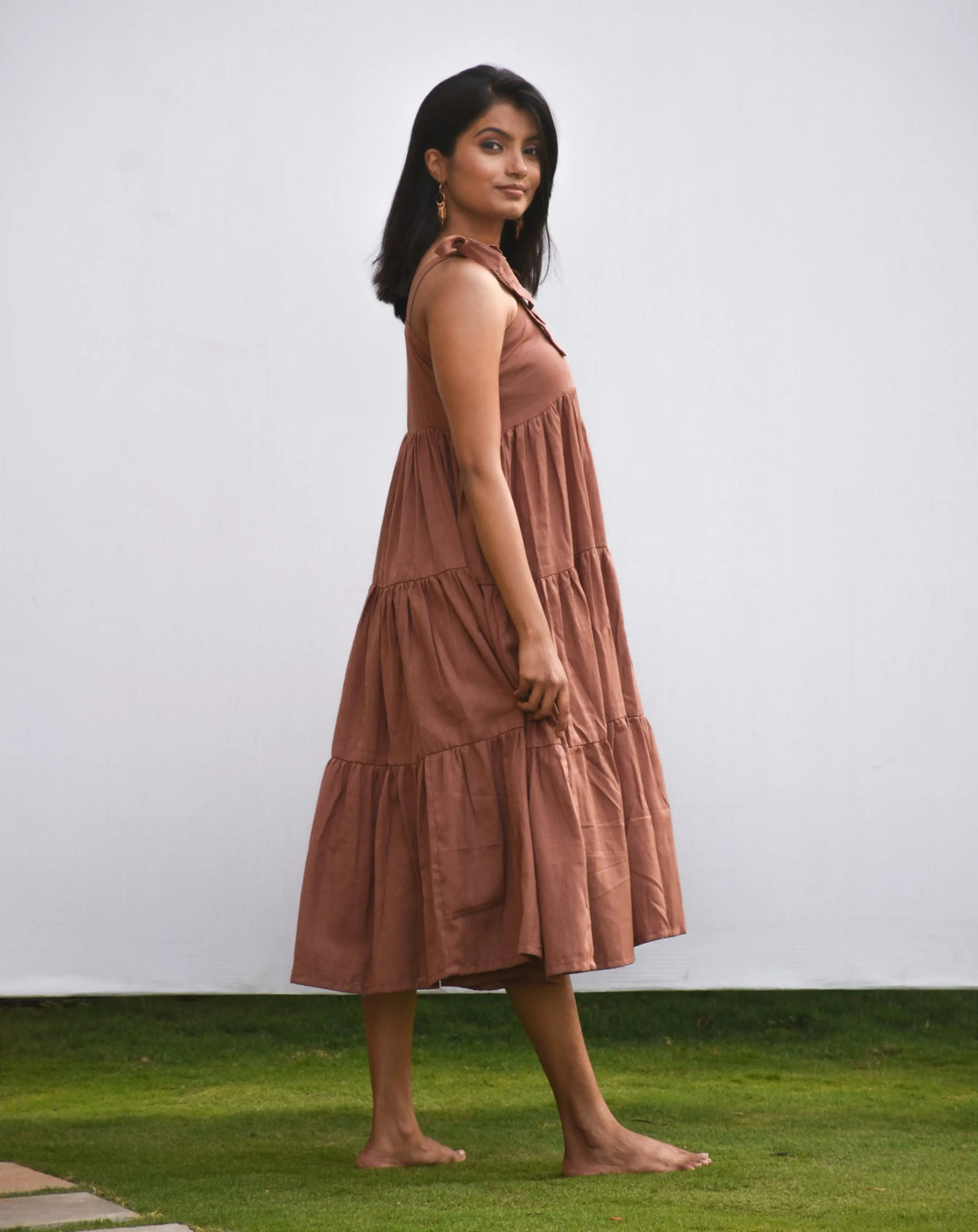Brown cotten-linen tiered midi dress with tie-up shoulder straps.